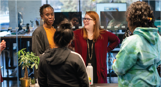 Mortenson employees talking with high-school-age youth about the ACE Mentor Program and opportunities that exist in the construction industry after high school. 