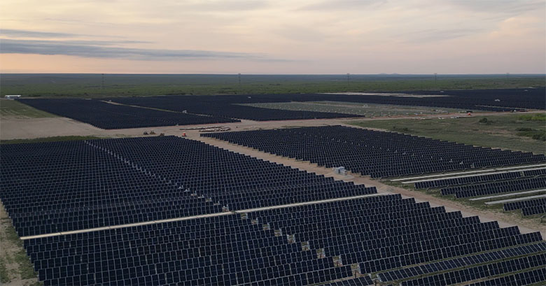 Aerial view of a large field with rows of solar panels