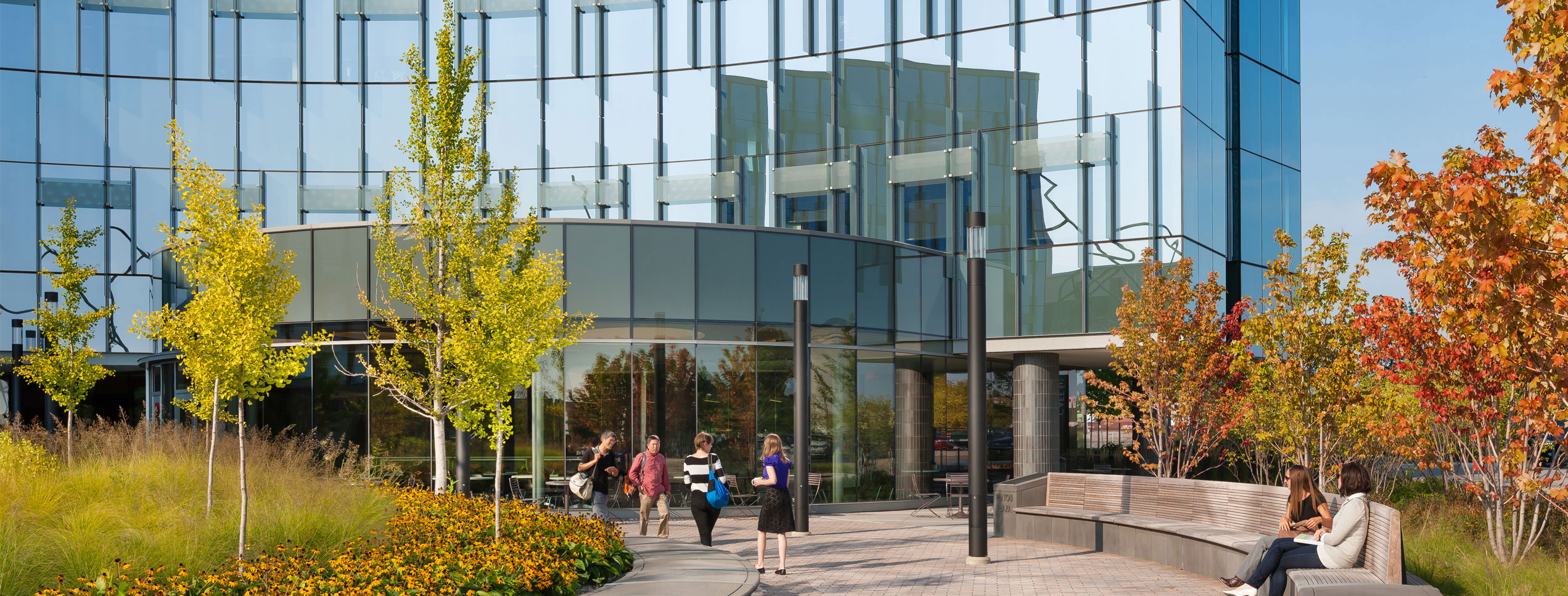 entry of glass building with people exiting